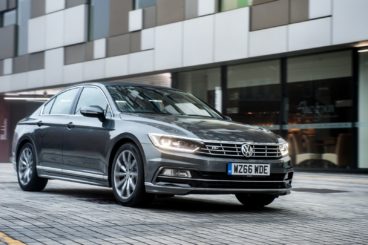 dark grey Volkswagen Passat driving in the city