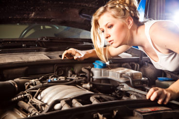 blonde woman inspecting her car
