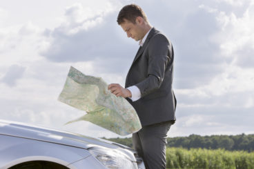 man looking at map at the side of the road - distractions when driving