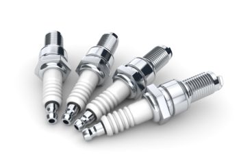 four spark plugs isolated on white background