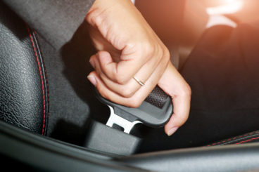 Business women putting on her seatbelt - top 10 safe cars