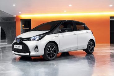 Black and white Toyota Yaris inside a showroom with marble floor and orange lighting
