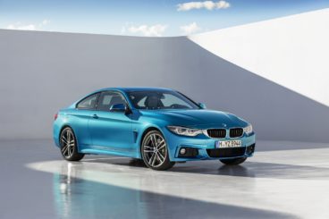 metallic blue bmw 4 series coupe isolated in white walls with blue skys and shadows
