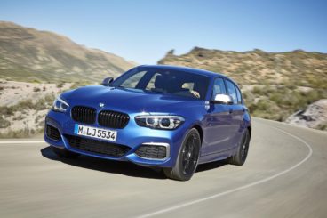 metallic blue bmw m140i turning round corner in desert setting