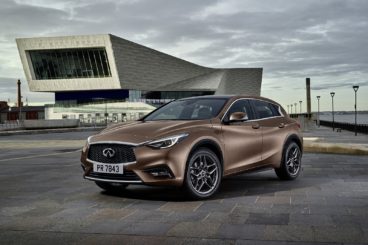metallic coloured infiniti q30 parked in car park in front of modern building