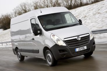 white vauxhall movano driving along wet road with snowy hills to the side