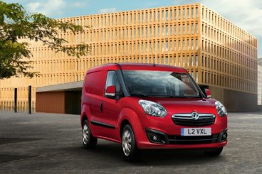 Red Vauxhall Combo Van infront of large building