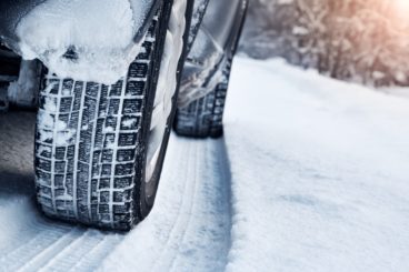 close up of tyres on a car driving through snow