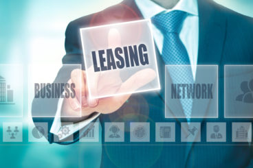 A man using a touch screen tapping on the word leasing