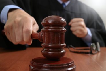 zoomed in picture of a court judge throwing down his gavel