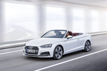 a metallic white audi a5 diesel cabriolet driving down tarmac road under a tunnel