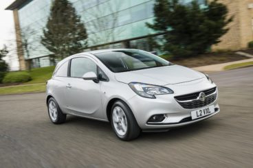 silver corsavan driving quickly round a corner on tarmac road