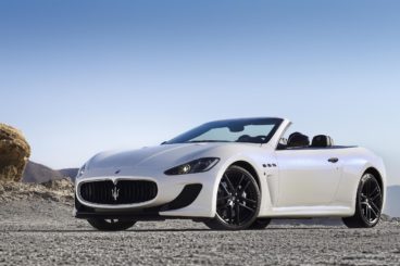 white maserati grancabrio convertible parked on gravel road on a sunny day