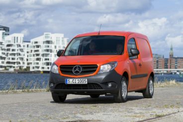 organge mercedes-benz citan van parked near harbour and modern buildings