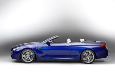 side view of a metallic blue bmw m6 convertible isolated on a black and white background