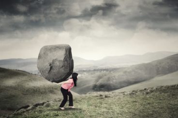 Young person carrying boulder