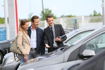 Man and woman with car salesman deciding on their next vehicle they want to buy.