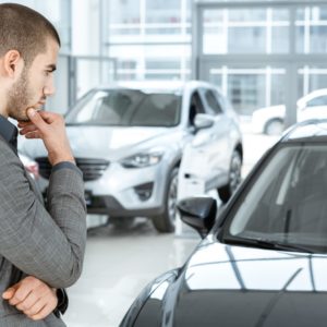 man looking at his old car Man looking at a car thinking about getting a new vehicle.