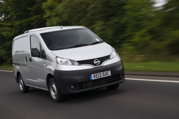 silver nissan nv200 combi diesel estate driving down tarmac road with blurred green trees in the background. Van leasing self employed