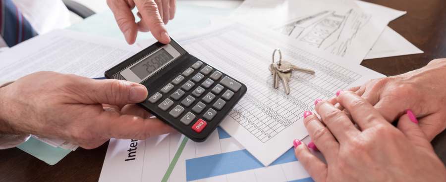 Man showing sum on calculator to woman