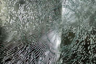 smashed glass that has been kept together with a security film showing how the device works