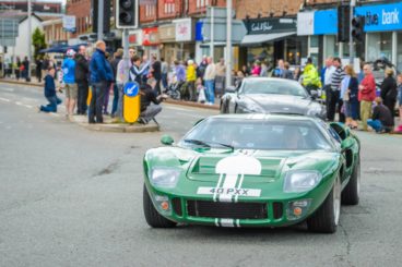 green rally ford gt40 driving through city for a car show