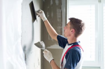 young worker plastering wall