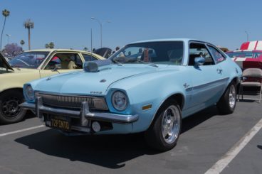 vintage light blue ford pinto parked amongst other vintage ford cars in a car park