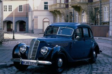 BMW 335 parked on a cobbled street with buildings behind it
