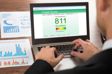 Close-up Of A Businessman Checking Credit Score Online On Laptop to check whether he qualifies for vehicle leasing.