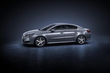 side view of a peugeot 508 diesel saloon in a spotlight isolated on a grey/blue background