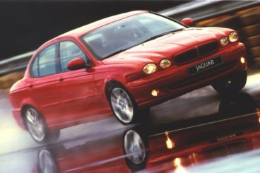 Jaguar X Type in red driving on a track in the rain