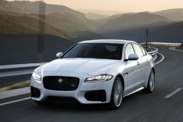 Jaguar XF Saloon in white driving along the road