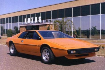 Orange Lotus Esprit parked outside a building
