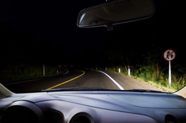 car dashboard driving at night with lights on