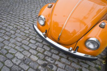 Classic bright orange Volkswagen Type 1 Beetle, known locally as a Fusca, parked on a cobblestone street in the Santa Teresa neighborhood. beetlevwvolkswagencarclassicbrazilianabstractautomobilebrasilbrazilbugclose-upcobblecobblestonesdefrom abovefuscahorizontaljaneiroorangeoutdoorsparkedpartpart ofphotophotographphotographyriorio de janeirosantasanta teresasouth americastreetteresatraditionalvolkswagen beetlevolkswagen bugShow more