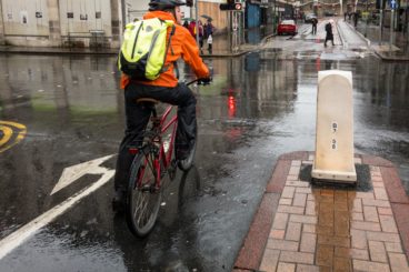 Guy wearing high visibility bag whilst riding his bike