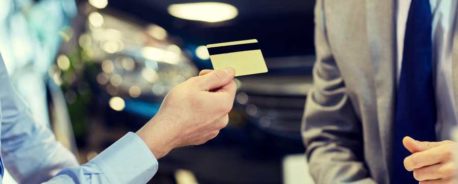 Person handing over Credit Card in dealership