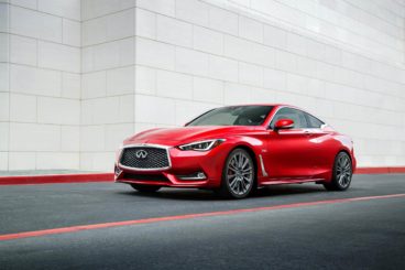 Red Infiniti Q60 parked on a road with a white background
