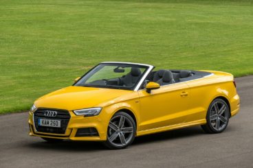 a yellow audi a3 cabriolet parked on tarmac with green grass in the background
