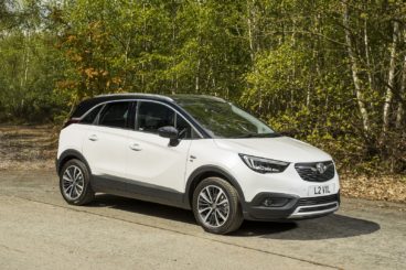 a white vauxhall crossland x parked on tarmac within a british forest setting