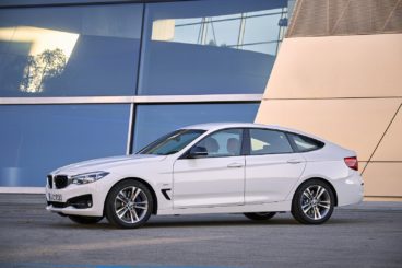 a white BMW 3 Series Gran turismo diesel hatchback parked outside a modern building