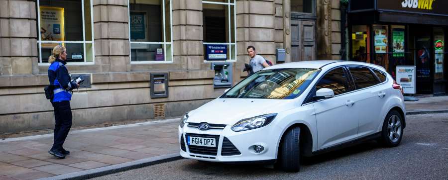 Registering a leased vehicle - Parking warden and car with ticket on windscreen