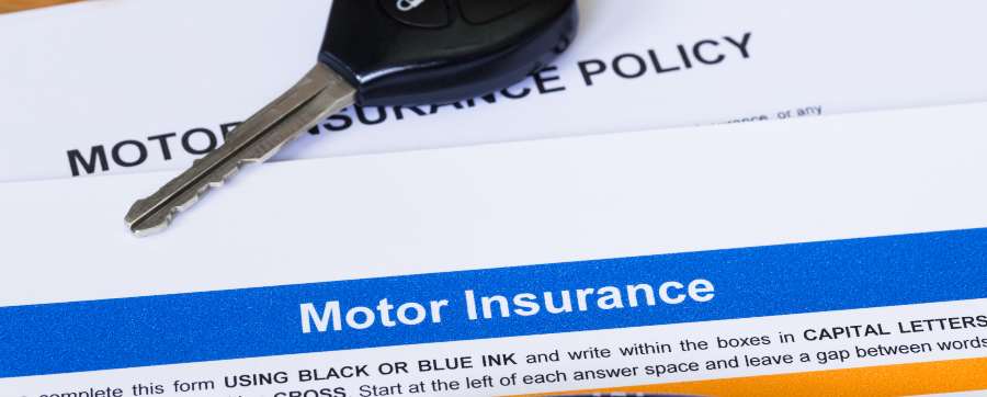 Car key on insurance papers