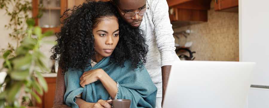 Can't keep up repayments - Worried couple looking at computer