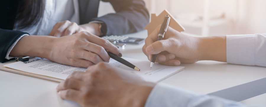 Two people signing a contract
