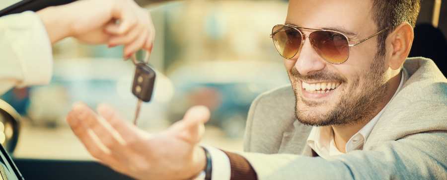 Business leasing - man in a suit eing handed a key fob