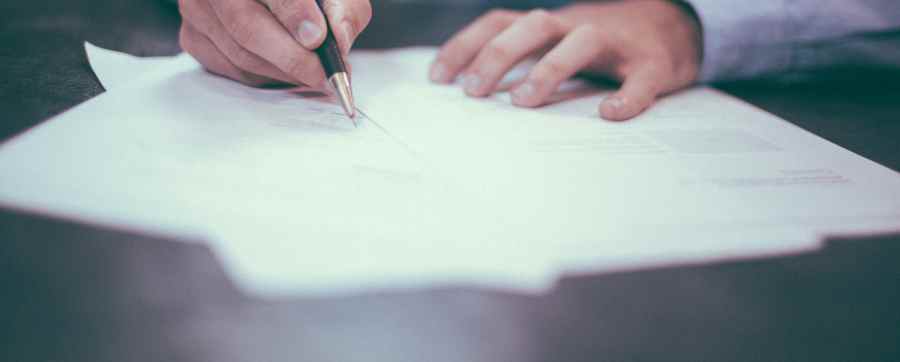 Person looking through and signing paperwork