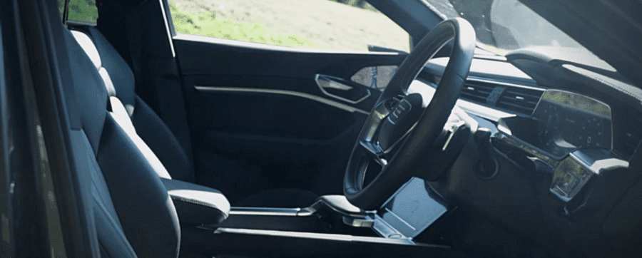 Front interior of the Audi e-tron Sportback with black leather and white stitching the seats and the steering wheel