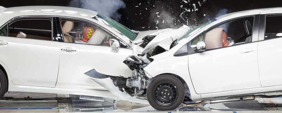 two white cars crashing into each other in a safety crash test